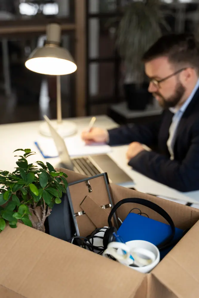 Empleado recogiendo pertenencias en caja: gestión laboral